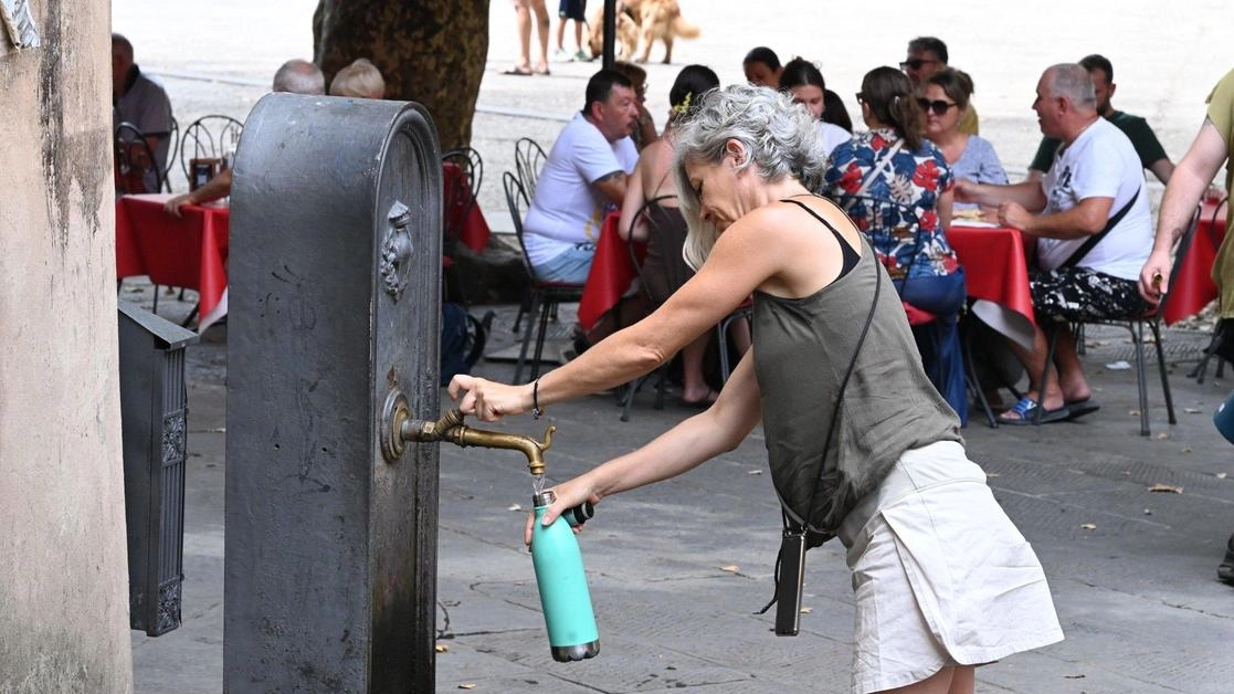 Una turista riempie la borraccia a una fontana (foto Alcide) Una turista riempie la borraccia a una fontana (foto Alcide)