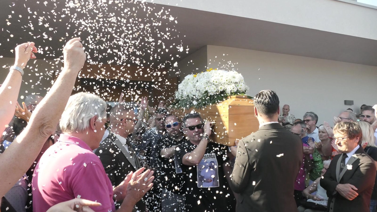 Gli amici con le magliette con la foto di Marco Riccomagno trasportano la bara. All'uscita della chiesa fiori e coriandoli bianchi (Foto Umicini) Gli amici con le magliette con la foto di Marco Riccomagno trasportano la bara. All'uscita della chiesa fiori e coriandoli bianchi (Foto Umicini)