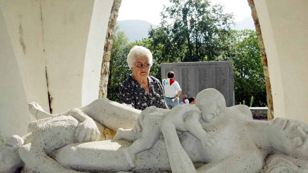 Una donna in preghiera davanti al monumento che ricorda le vittime