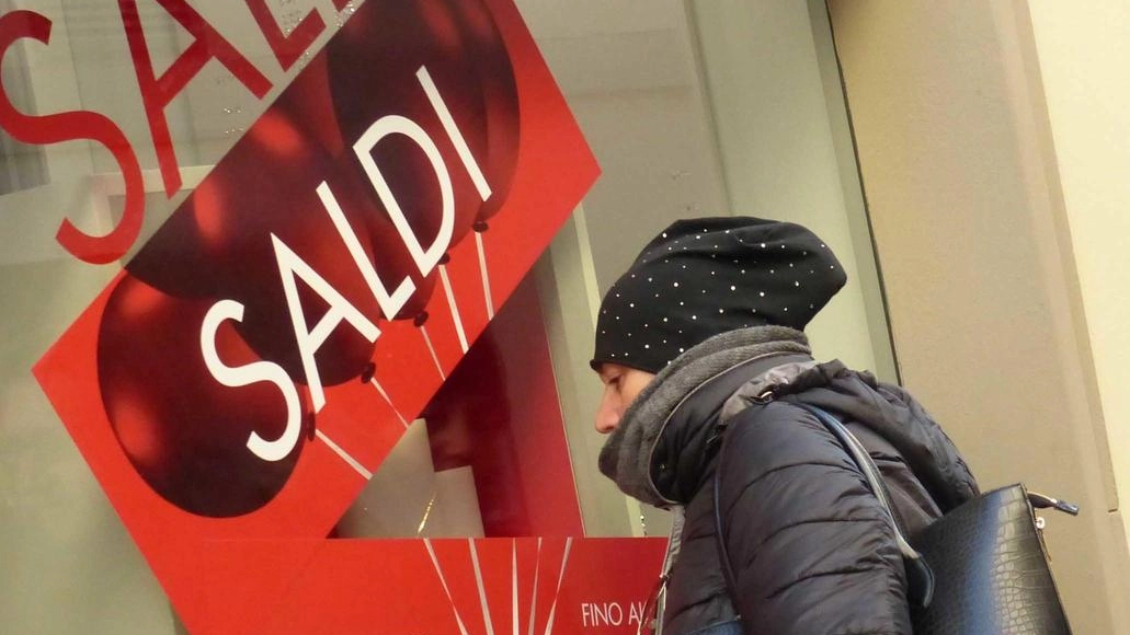 Si allestiscono le vetrine per i saldi nei negozi del centro con le vetrofanie che riportano le percentuali di sconto Si allestiscono le vetrine per i saldi nei negozi del centro con le vetrofanie che riportano le percentuali di sconto