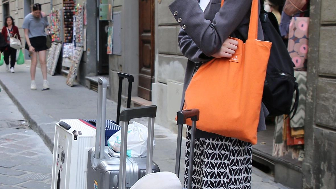 Una giovane turista in centro con l’immancabile trolley. In molti palazzi i fiorentini residenti sono ormai mosche bianche Una giovane turista in centro con l’immancabile trolley. In molti palazzi i fiorentini residenti sono ormai mosche bianche