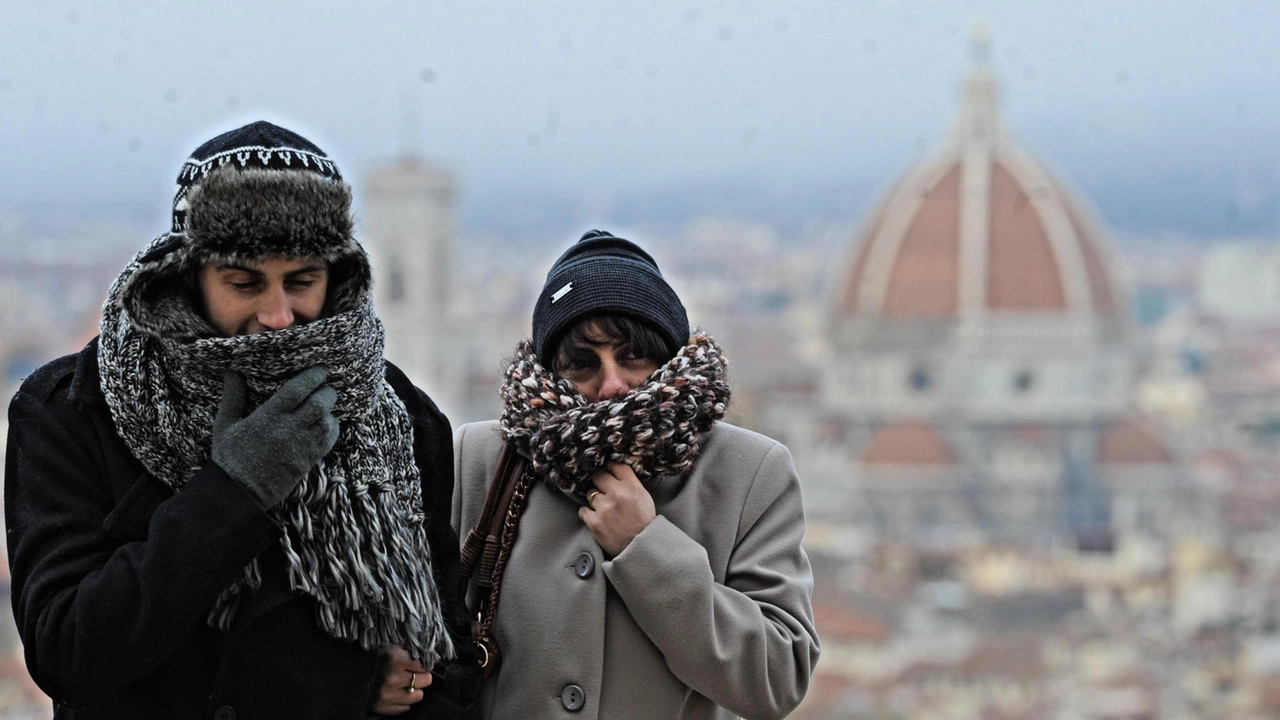 Un uomo e una donna si riparano dal freddo con sciarpe e cappelli a Firenze Un uomo e una donna si riparano dal freddo con sciarpe e cappelli a Firenze