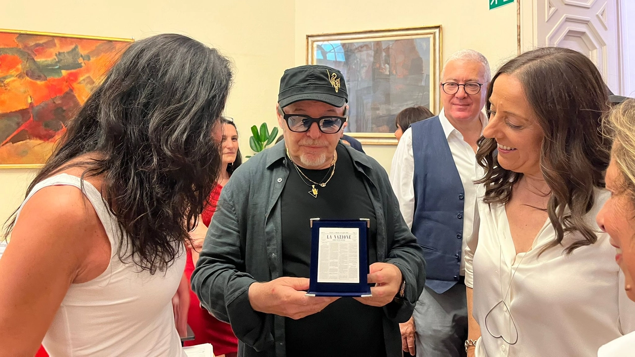 La caporedattrice della Nazione di Firenze Erika Pontini consegna la targa dei 165 anni del giornale a Vasco Rossi. A destra la sindaca Sara Funaro