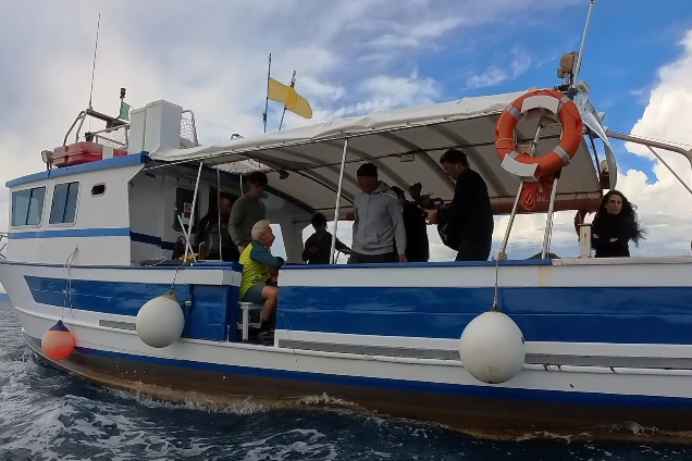 Giovanni Storti sulla barca si appresta a rilasciare in mare le anfore che faranno da "casa" per i polpi