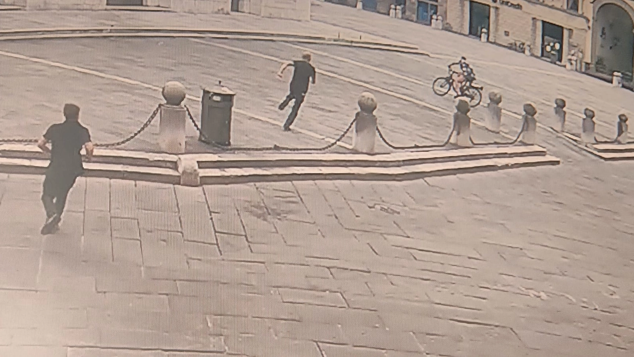 Lo scippatore in fuga (in bicicletta) ripreso dalle telecamere di sorveglianza Lo scippatore in fuga (in bicicletta) ripreso dalle telecamere di sorveglianza