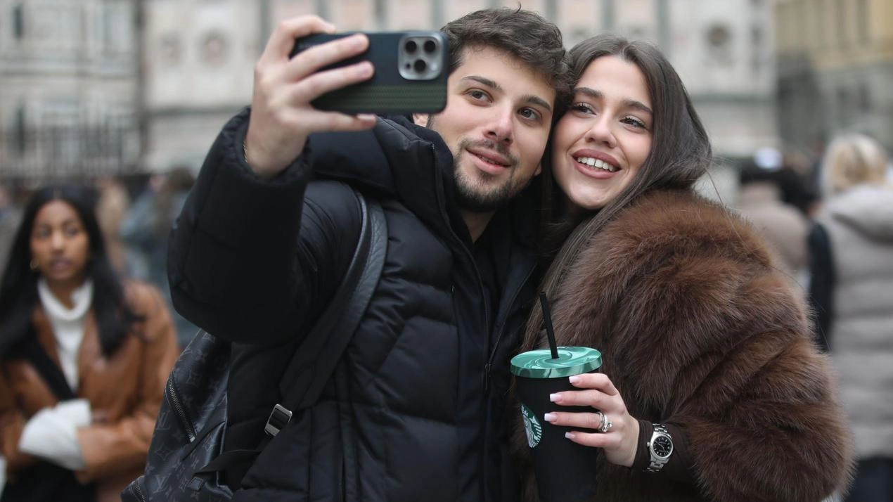 Due turisti si scattano un selfie in piazza Duomo Due turisti si scattano un selfie in piazza Duomo