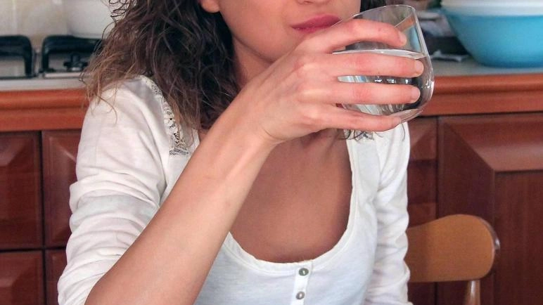 Una ragazza beve un bicchiere di acqua (foto di repertorio) Una ragazza beve un bicchiere di acqua (foto di repertorio)