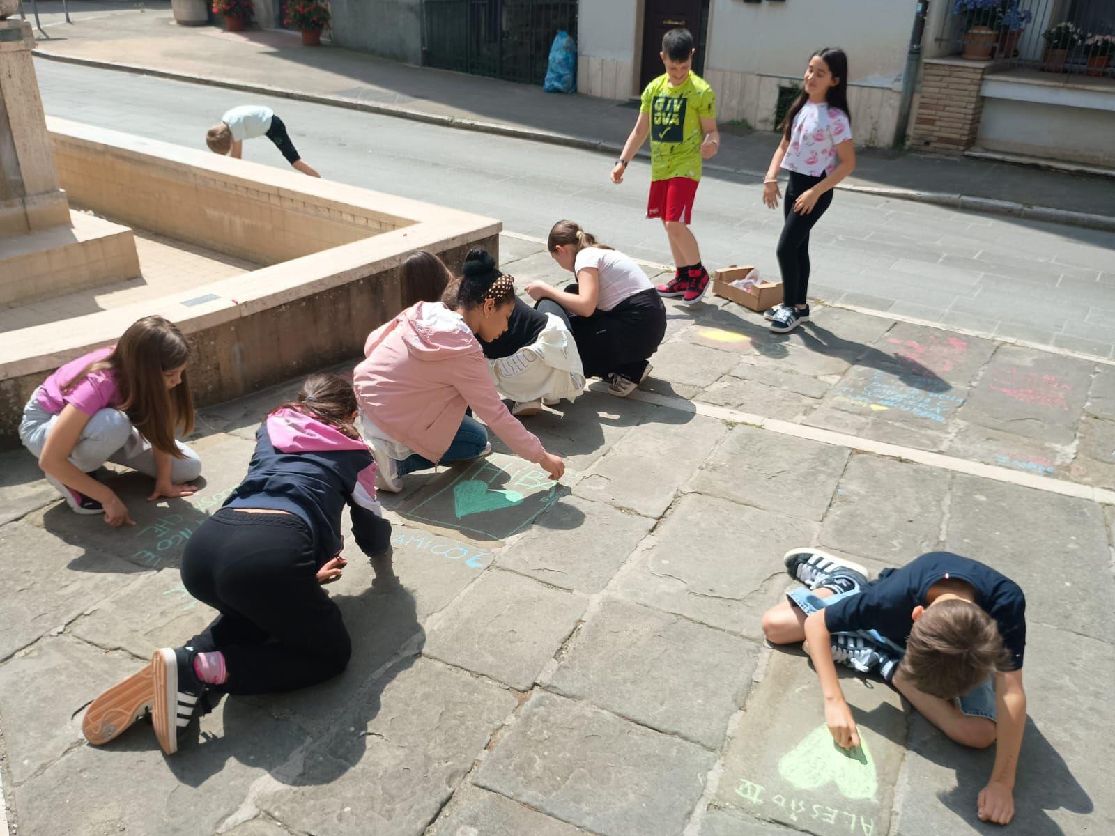 Gli alunni stendono il "bucato poetico" e colorano con i gessetti le strade di Tavernelle Gli alunni stendono il "bucato poetico" e colorano con i gessetti le strade di Tavernelle