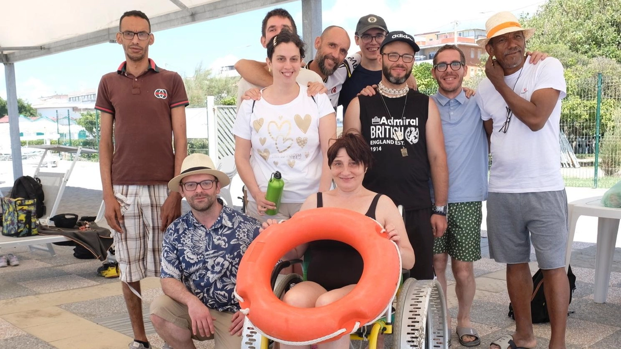 Un gruppo di frequentatori della spiaggia di Marinella attrezzata per accogliere i ragazzi con disabilità e le loro famiglie Un gruppo di frequentatori della spiaggia di Marinella attrezzata per accogliere i ragazzi con disabilità e le loro famiglie