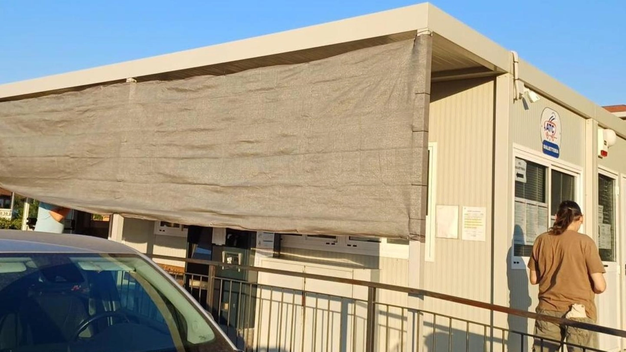 Il grande lenzuolo alla biglietteria per tenere al riparo dal sole Il grande lenzuolo alla biglietteria per tenere al riparo dal sole