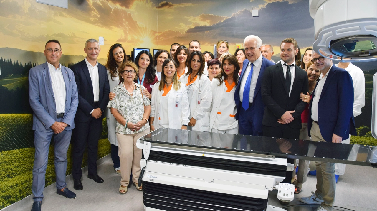 Foto di gruppo in Radioterapia: per il nuovo acceleratore lineare sono stati ammodernati gli ambienti e le pareti sono oggi abbellite con vedute della campagna senese Foto di gruppo in Radioterapia: per il nuovo acceleratore lineare sono stati ammodernati gli ambienti e le pareti sono oggi abbellite con vedute della campagna senese