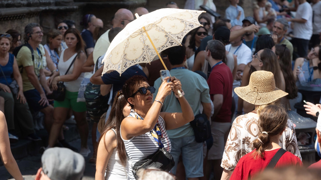 Ferragosto, turisti in centro a Firenze: ci si ripara dal sole (foto Giuseppe Cabras/New Press Photo)