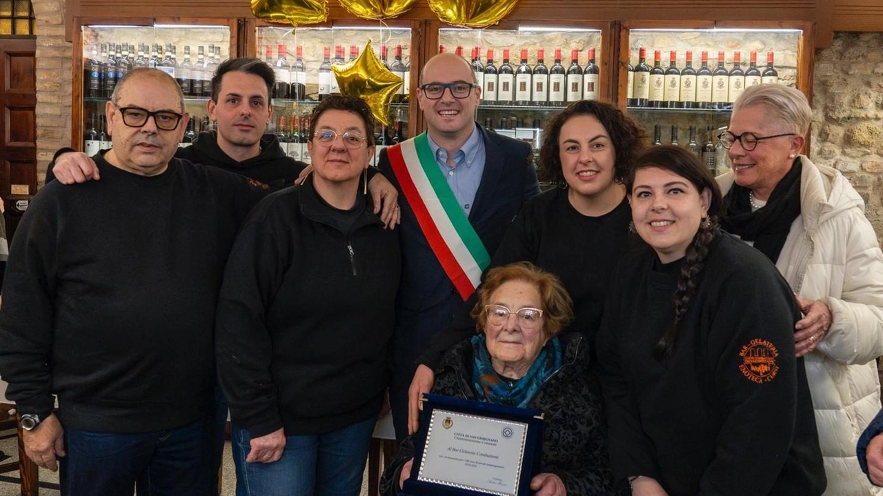 Andrea Marrucci, primo cittadino di San Gimignano, ha consegnato una targa commemorativa al popolare ‘Caffè gelateria Combattenti’ per i suoi 100 anni Andrea Marrucci, primo cittadino di San Gimignano, ha consegnato una targa commemorativa al popolare ‘Caffè gelateria Combattenti’ per i suoi 100 anni
