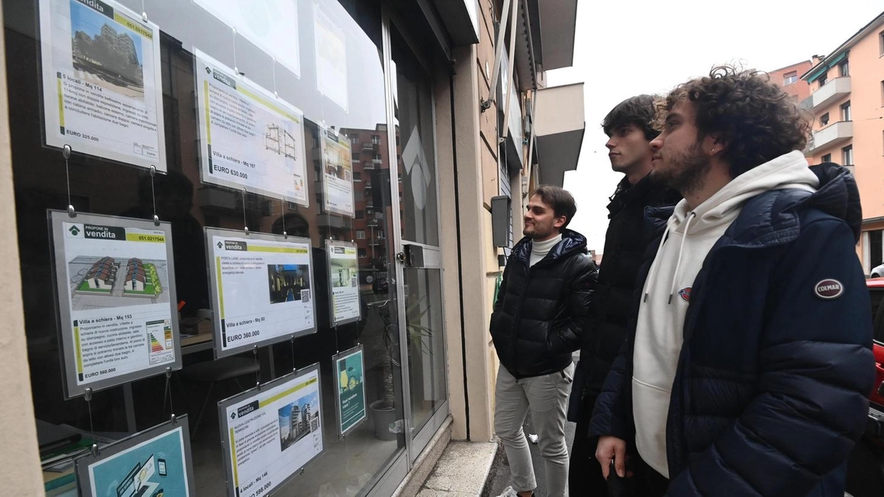 Giovani guardano la bacheca di un’agenzia per cercare una casa in affitto Giovani guardano la bacheca di un’agenzia per cercare una casa in affitto