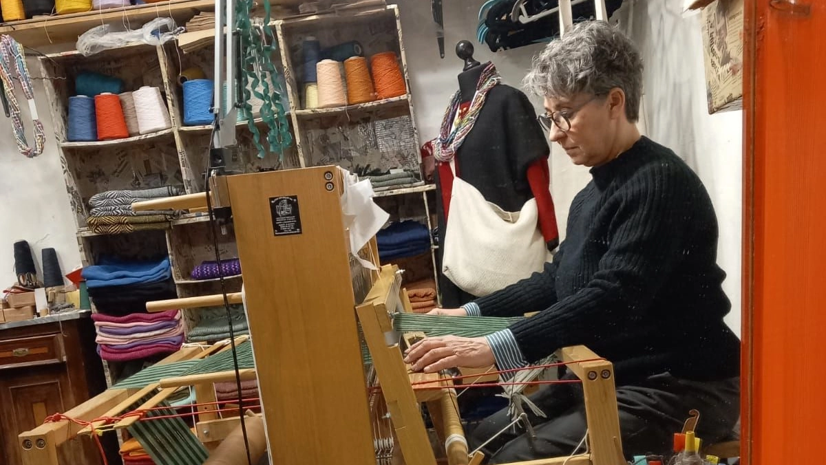 Paola mentre tesse al telaio nella bottega artigianale Paola mentre tesse al telaio nella bottega artigianale