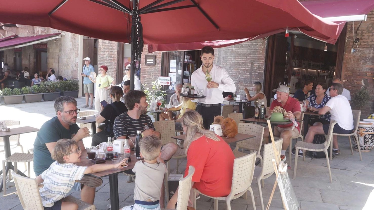 Turisti ai tavoli dei ristoranti in Piazza del Campo e nelle strade limitrofe; quest’anno aver rimandato di un giorno non ha aiutato perchè ci sono state cancellazioni Turisti ai tavoli dei ristoranti in Piazza del Campo e nelle strade limitrofe; quest’anno aver rimandato di un giorno non ha aiutato perchè ci sono state cancellazioni