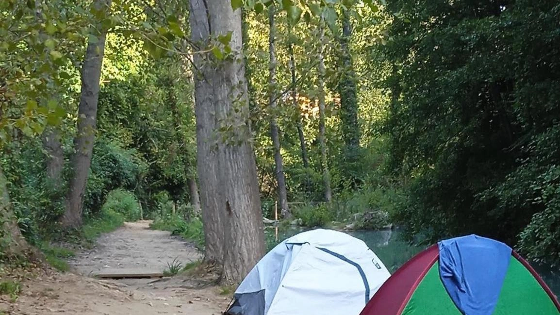 Allestimento di bivacchi e tende lungo le sponde del fiume, una zona potenzialmente pericolosa