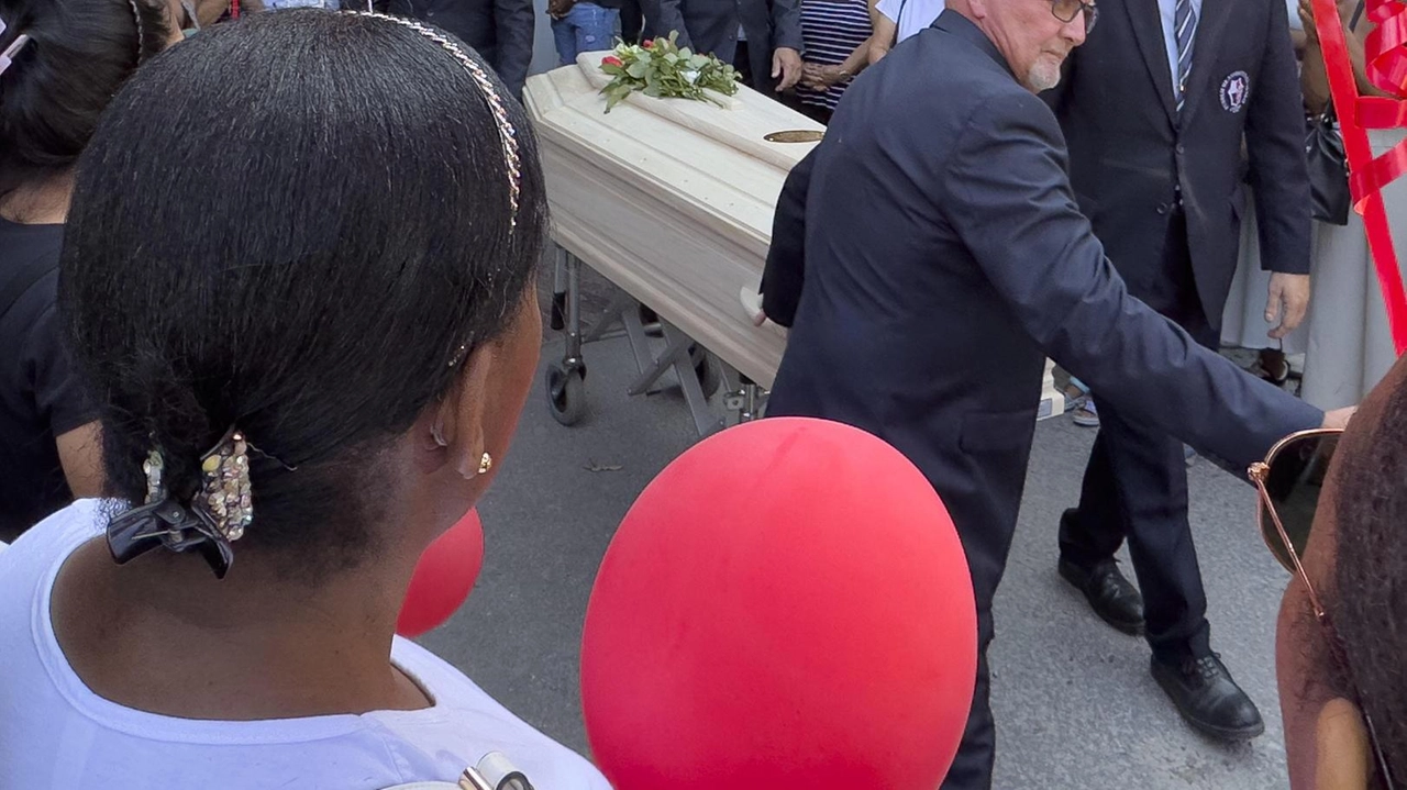 Il feretro. accolto da un applauso. In alto a sinistra don Giglio e a destra i palloncini per l’addio Il feretro. accolto da un applauso. In alto a sinistra don Giglio e a destra i palloncini per l’addio