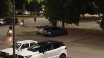 Alcuni motorini mentre viaggiano a tutta velocità vicino a un parco Alcuni motorini mentre viaggiano a tutta velocità vicino a un parco