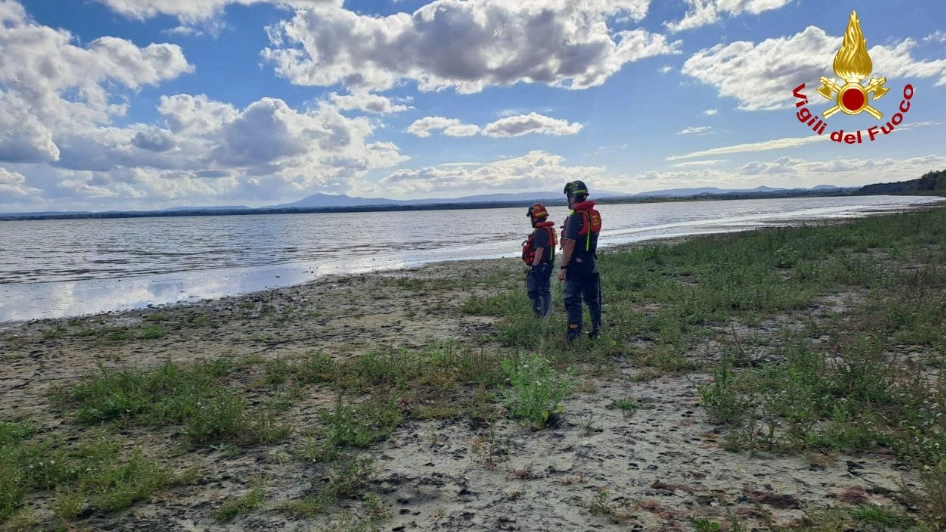 Vigili del fuoco sulle sponde del lago Trasimeno. Il corpo è stato visto da un elicottero che sorvolava la zona