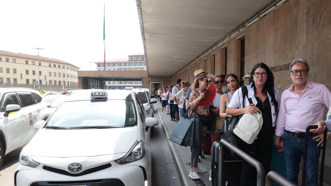 Lunghe code fuori dalla stazione, in attesa di prendere un taxi Lunghe code fuori dalla stazione, in attesa di prendere un taxi
