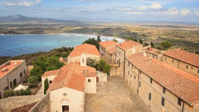 PER CENNAMO Aerial view of the old city Populonia, Tuscany, Italy. In the background the bay of Baratti. Populonia is noteworthy for its Etruscan remains which are shown in a large archeological park.