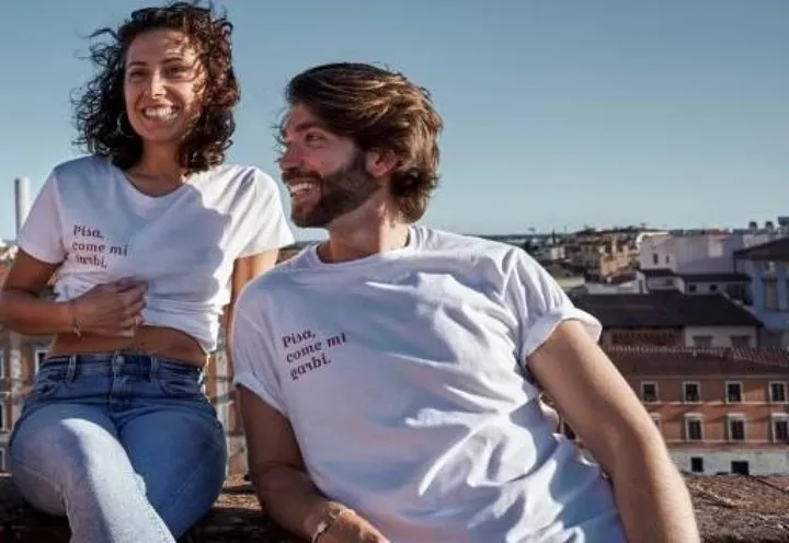 Nico Tedeschi, insieme a Giulia Bargagna, indossa la maglietta solidale; a destra, Federico Faccini mostra la t-shirt