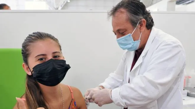 Una ragazza viene vaccinata da un medico all’hub del Mandela