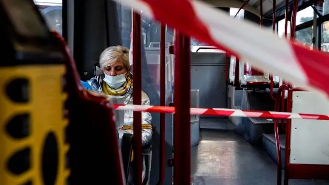 A woman wears a protective mask inside a public transport bus during the emergency blockade for the Coronavirus Covid-19 in Rome, Italy, 16 April 2020. ANSA/ANGELO CARCONI