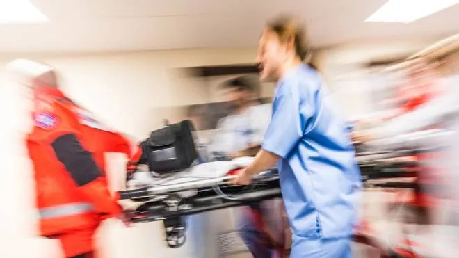 Side view of medical personnel hurrying with patient on stretcher to emergency. Motion blur. Medicine and healthcare concept.