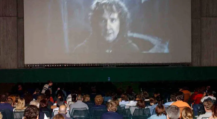 Pubblico intento a seguire un film in un cinema all’aperto (foto di archivio)
