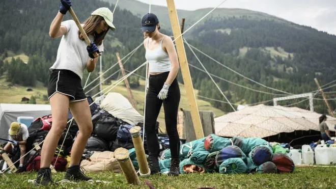 epa10088336 Girl scouts help to build a tent at the campground on the first day of the Federal Scout Camp 'mova' in the Goms Valley in Ulrichen, Switzerland, 23 July 2022. The biggest scout camp ever will take place in the Goms Valley from 23 July to 06 August 2022. This unique event, which takes place every 14 years, gathers about 30,000 scouts from all over Switzerland during two weeks.  EPA/GABRIEL MONNET