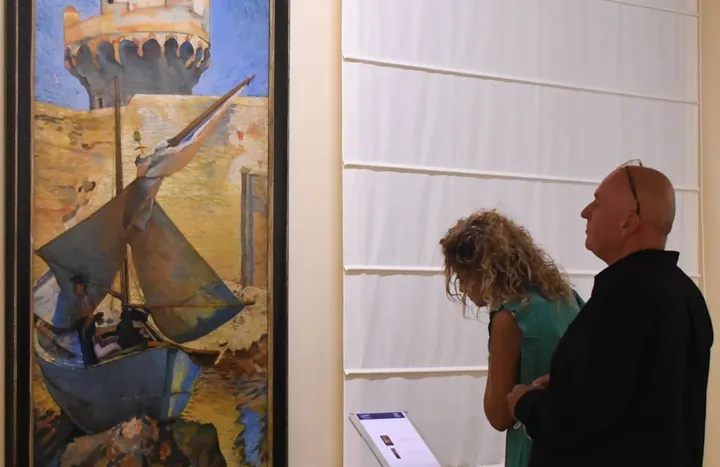 Due visitatori della mostra di pittura dedicata al mare di palazzo Cucchiari