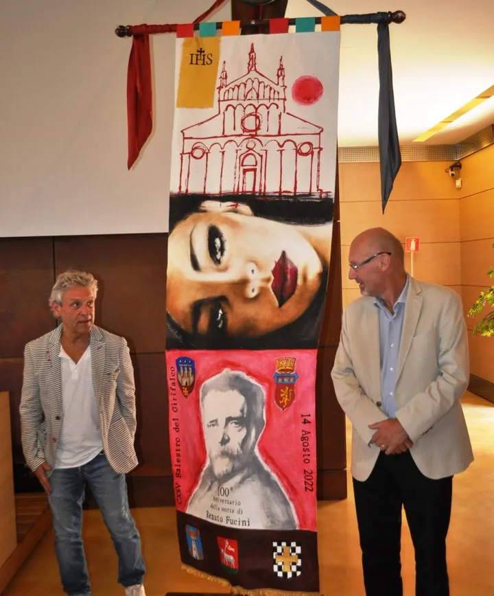 L’artista Fabio Calvetti e il sindaco Marcello Giuntini mostrano lo stendardo in palio questa sera