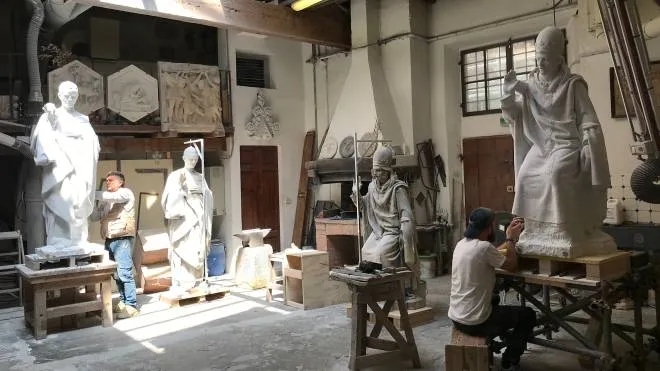 I restauratori al lavoro mentre scolpiscono la copia della scultura di Papa Celestino 1 proveniente dalla facciata ottocentesca del Duomo di Firenze