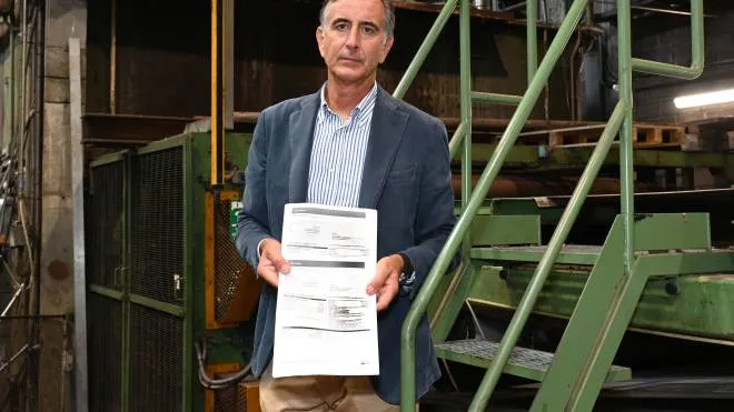 Giorgio Bartoli nel suo stabilimento mostra sconsolato la bolletta energetica (foto Alcide)
