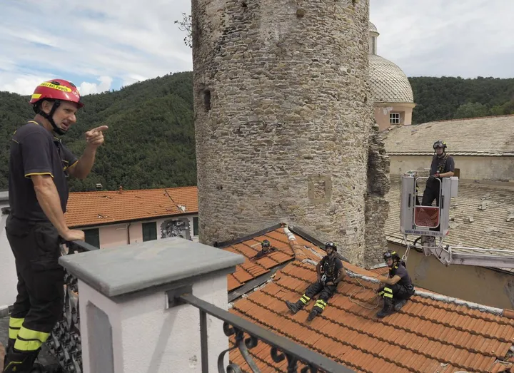 I vigili del fuoco sui tetti di Ortonovo. per rimediare ai danni provocati dal maltempo che hanno reso inagibile anche la chiesa del borgo (foto Pasquali)