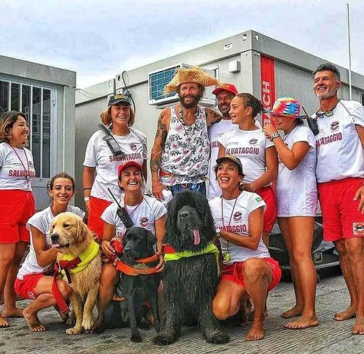 Dakota, il labrador nero, insieme a Jovanotti e al team di salvataggio in spiaggia