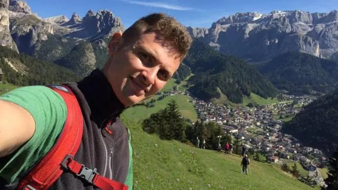 Una bella foto di Mattia Grossi, sorridente, circondato dalle montagne che amava ma che purtroppo gli sono state fatali
