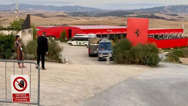 Sopra il nuovo suv Ferrari che sfreccia sulle strade di Lajatico; sotto il Teatro del Silenzio tinto di rosso