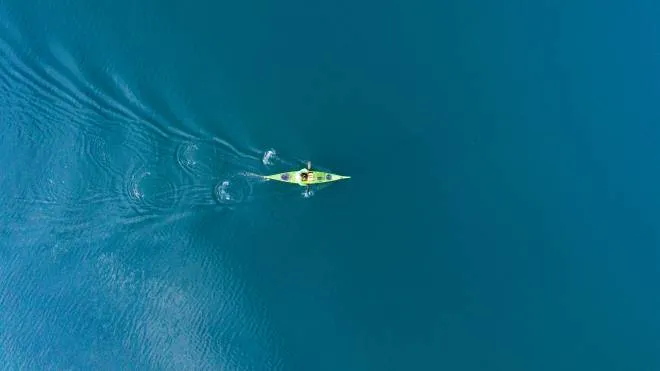 A drone shooting a kayak floating in lake