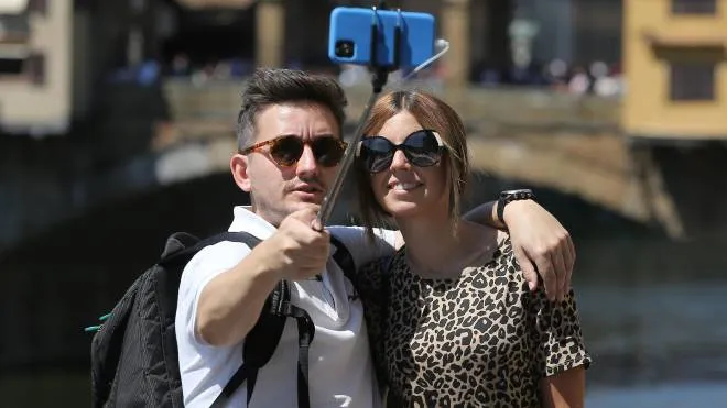 Selfie per una coppia di giovnai turisti con il Ponte Vecchio sullo sfondo