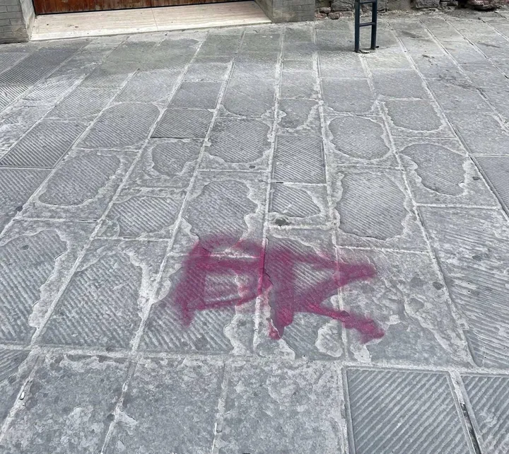 La scritta “comparsa“ in piazza Piccinino e l’assessore comunale Clara Pastorelli