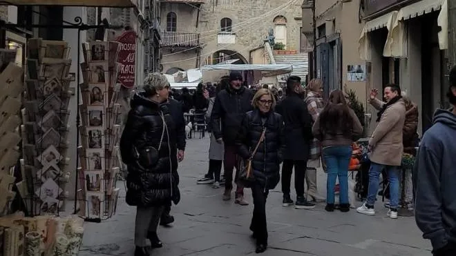 Gente per le vie del centro storico di Cortona, da sempre meta di tanti turisti