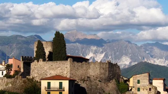 Il castello di Ameglia con le Alpi Apuane sullo sfondo e, sotto, il sindaco Umberto Galazzo