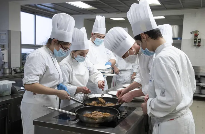 Studenti dell’alberghiero durante una lezione in cucina (. foto d’archivio