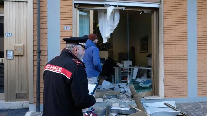 I carabinieri davanti alla porta sventrata della filiale Bper: il bancomat è stato sradicato in piena notte