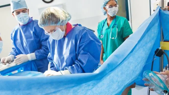 Surgical team performing Caesarean section on pregnant woman.