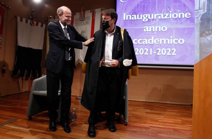 L’ultimo gesto da rettore di Pietro Cataldi che passa la toga a Tomaso Montanari per l’inizio del suo mandato (Foto Lazzeroni)
